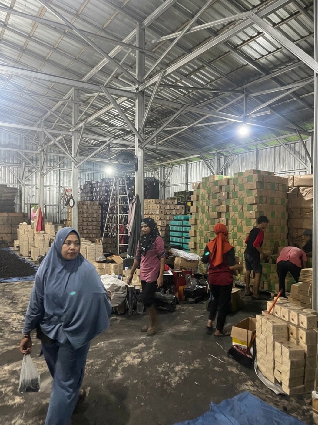 Workers packing finished charcoal cartons inside the KrakaCoal warehouse